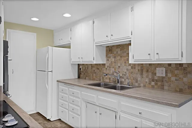 a kitchen with appliances a sink and cabinets