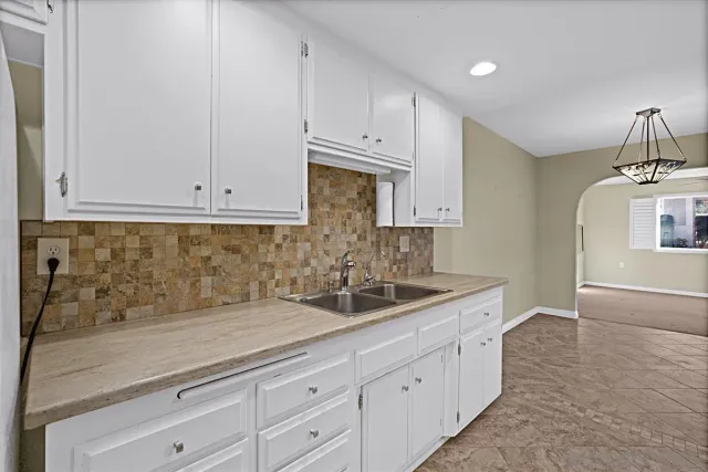 a kitchen with white cabinets and a sink