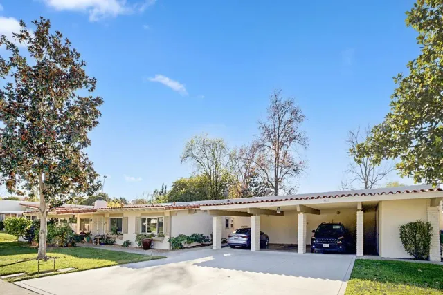 a view of a white house with a swimming pool and couches chairs