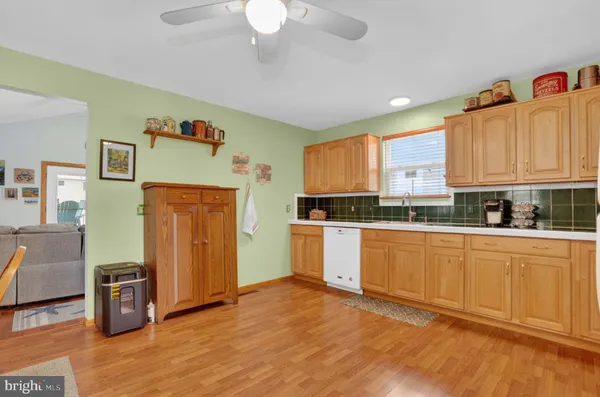 a kitchen with granite countertop white cabinets a refrigerator a sink and wooden floors