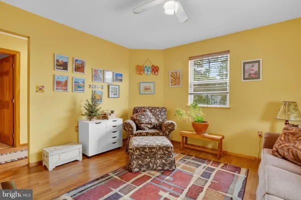 a living room with a couch and piano table with wooden floor