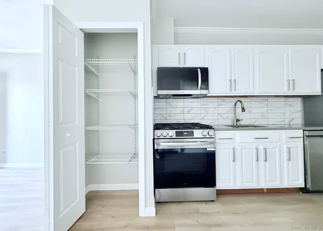 a kitchen with stainless steel appliances granite countertop a stove and a microwave