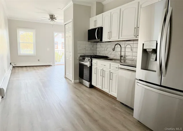 a kitchen with stainless steel appliances granite countertop a refrigerator a stove top oven a sink and dishwasher with wooden floor