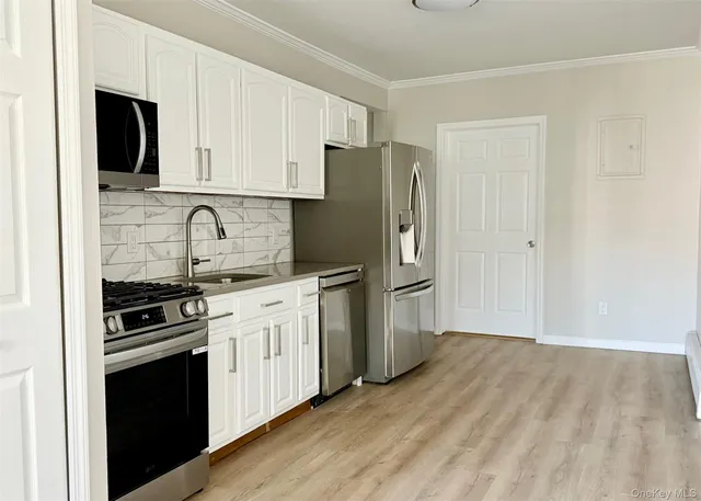 a kitchen with stainless steel appliances a refrigerator stove and microwave