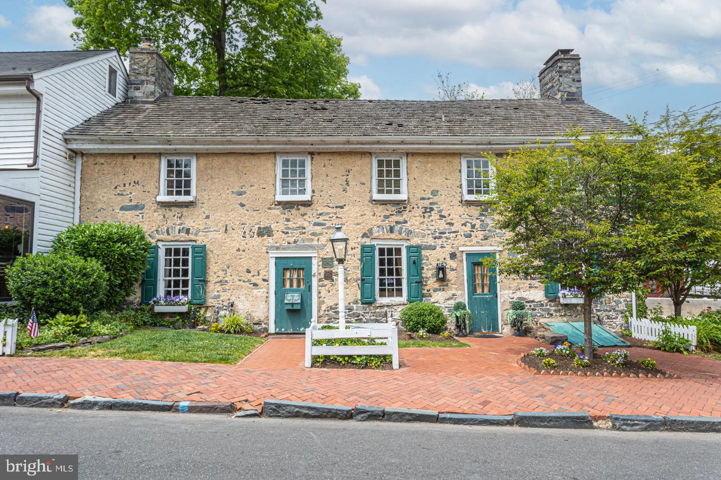 a front view of a house with a garden and plants