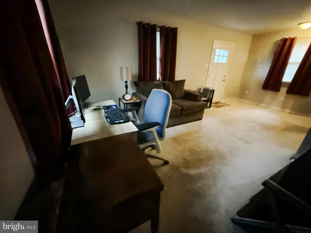 a view of a workspace with furniture and a mirror