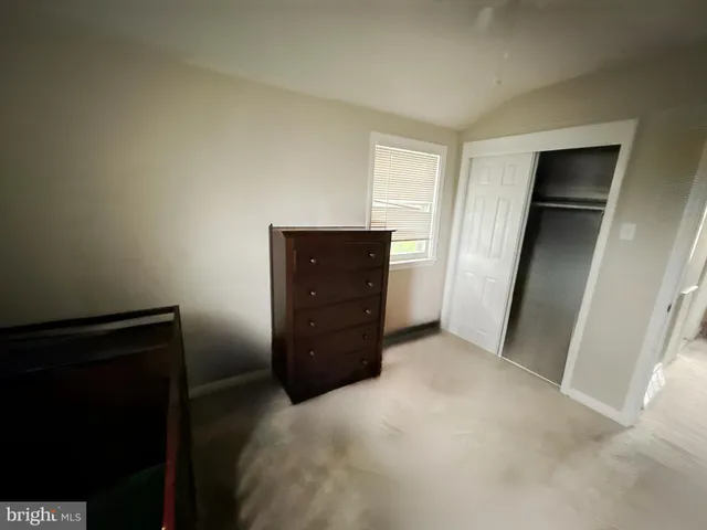 an empty room with closet and mirror
