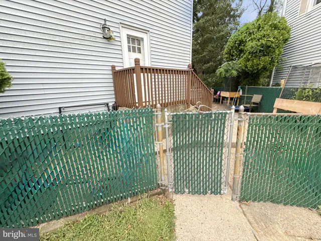 a view of a house with a small yard and wooden fence