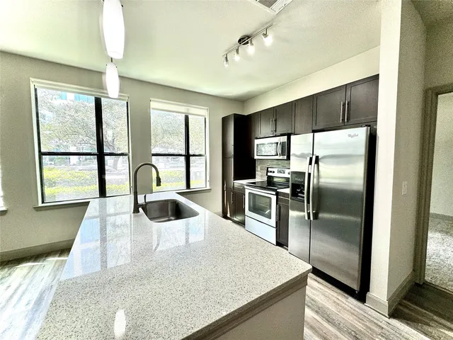 a kitchen with kitchen island a large counter top space appliances and a counter top space