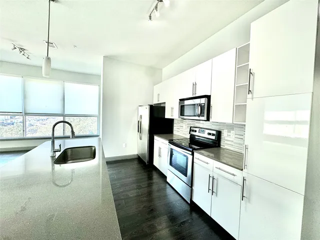 a kitchen with stainless steel appliances granite countertop a sink and a microwave