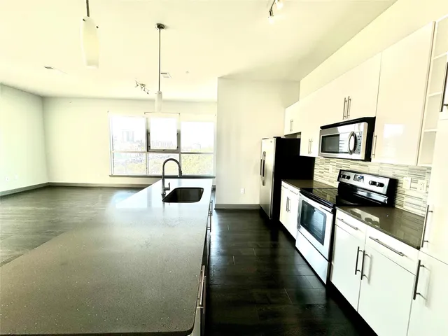 a kitchen with stainless steel appliances a microwave a stove and a refrigerator