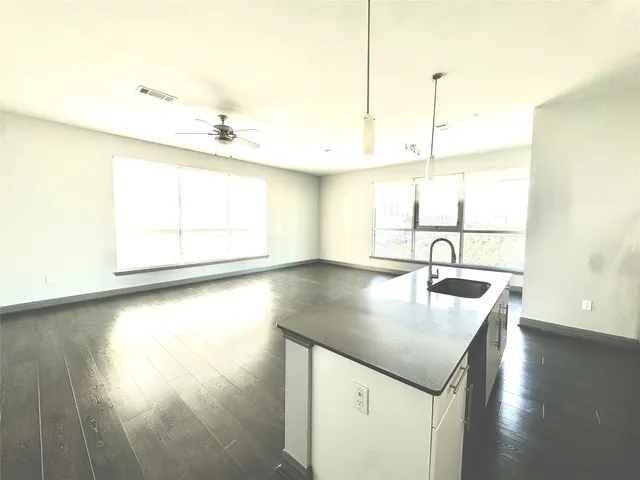a kitchen with kitchen island a sink appliances and wooden floor