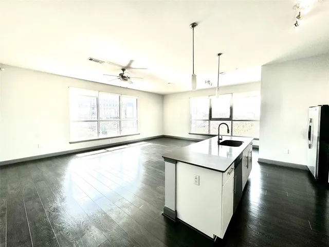 a kitchen with a sink a window and wooden floor