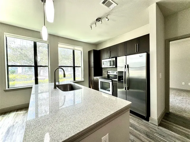 a kitchen with a refrigerator a sink and cabinets