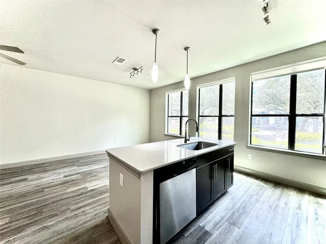 a kitchen with a sink and wooden floor