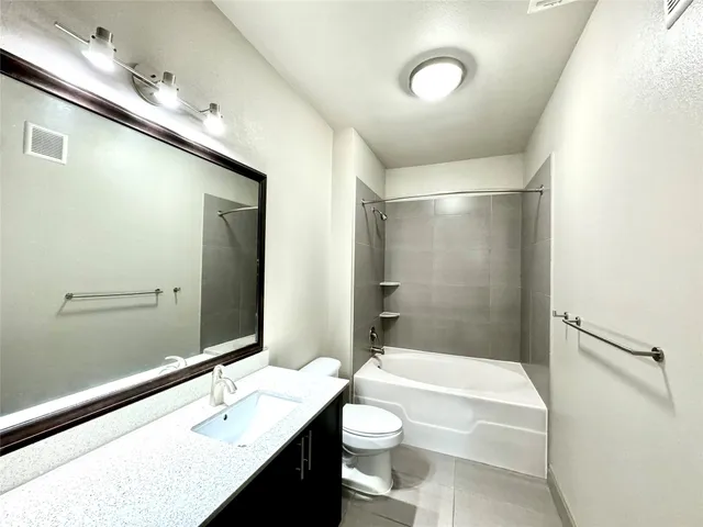 a bathroom with a double vanity sink a toilet and shower