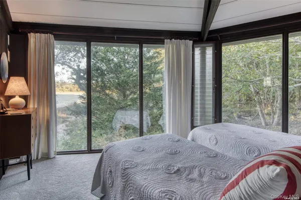 a bedroom with a bed and a large window