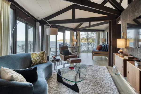 a living room with furniture and floor to ceiling windows