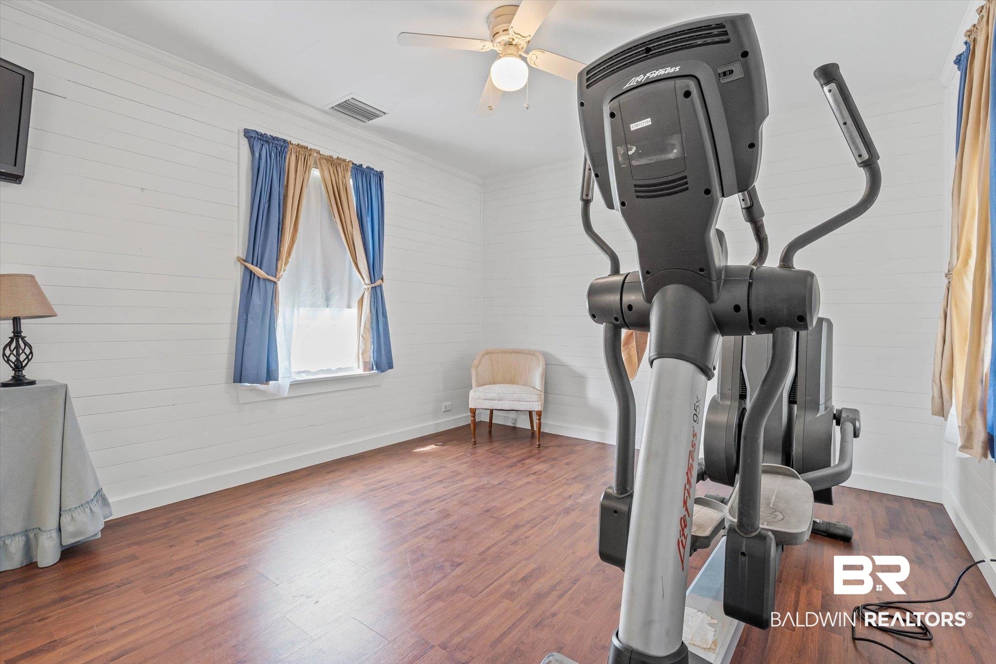 6175 South Grand Bay Wilmer Road Grand Bay, AL 36541 - Photo 27 of 42 Exercise area with dark wood finished floors, wood walls, and ceiling fan