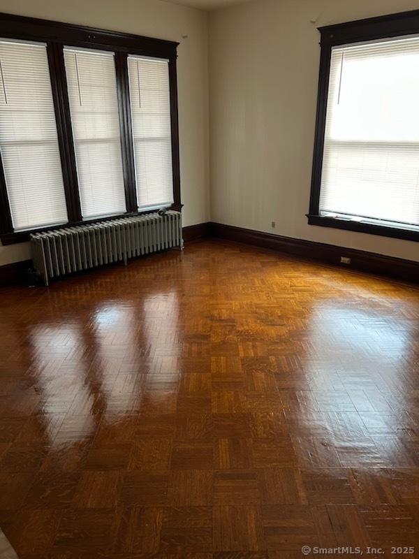 104 Howard Avenue New Haven, CT 06519 - Photo 3 of 9 an empty room with wooden floor and windows