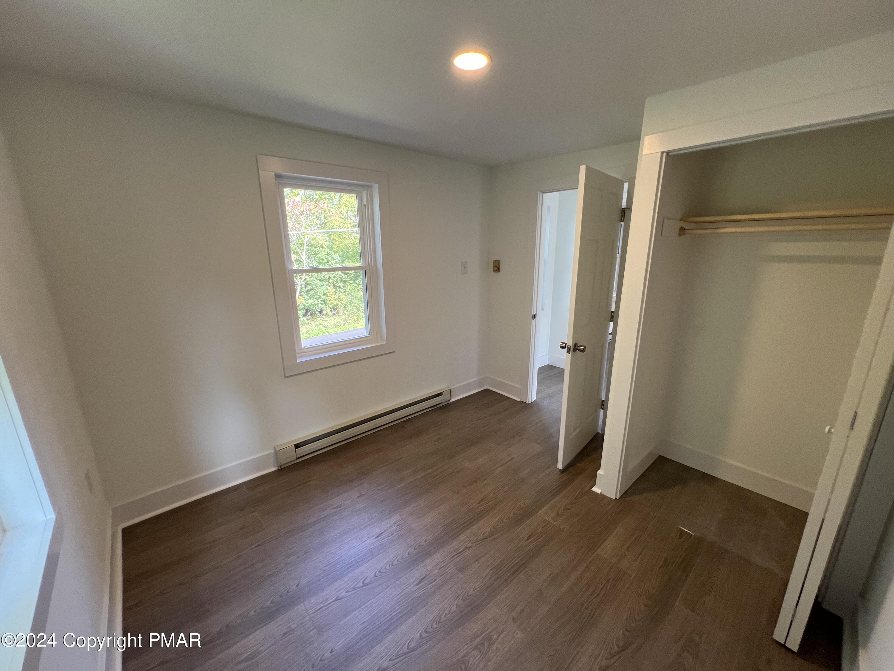 514 Fairground Road Gilbert, PA 18331 - Photo 12 of 20 an empty room with wooden floor and a window
