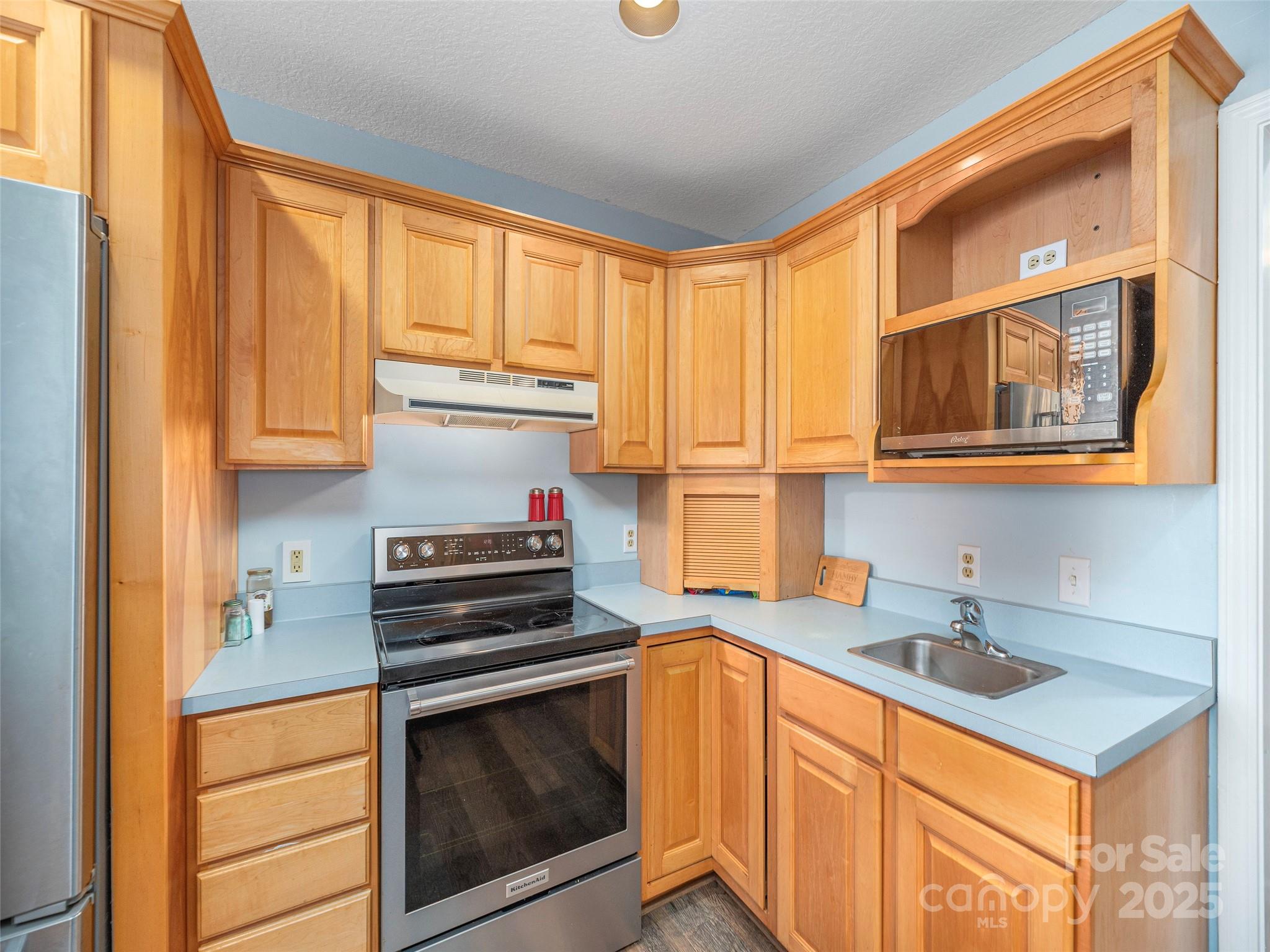 187 Turtle Creek Road Sylva, NC 28779 - Photo 10 of 36 a kitchen with stainless steel appliances granite countertop a stove a sink and a microwave