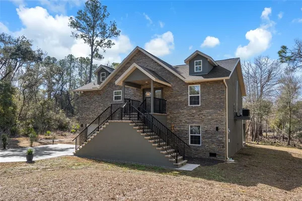 a view of an empty room with wooden floor and a ceiling fan