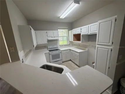 a kitchen with white cabinets and white appliances