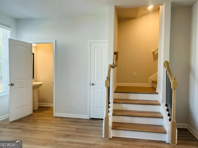 a view of front door with wooden floor and a bathroom