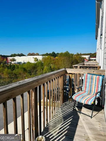 a view of a balcony with wooden floor and furniture