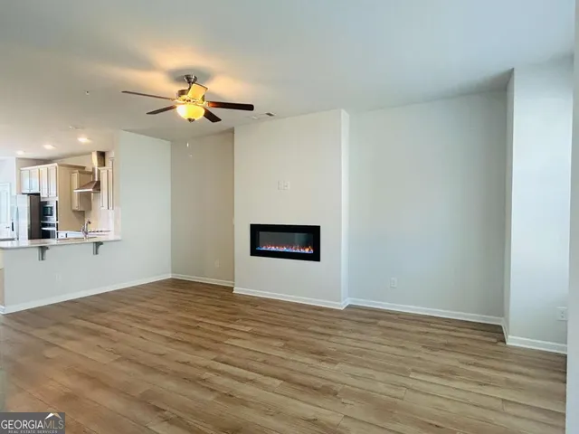 a view of an empty room with window and wooden floor
