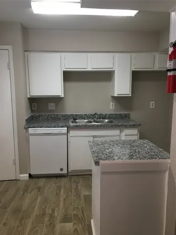 a kitchen with granite countertop a sink and a stove