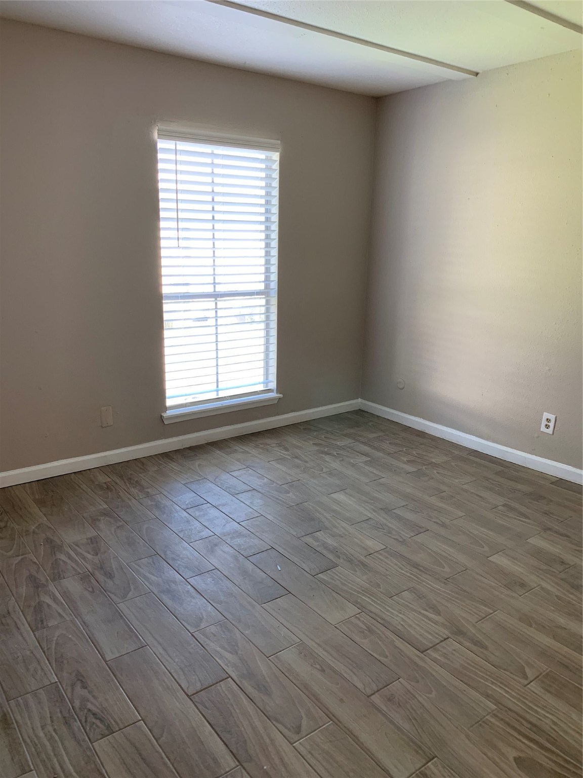 6200 West Tidwell Road, Unit 806 Houston, TX 77092 - Photo 7 of 10 a view of an empty room with wooden floor and a window