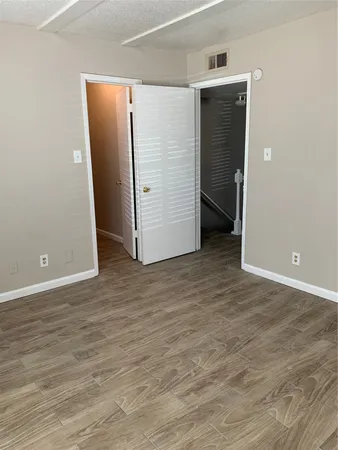 an empty room with wooden floor and closet