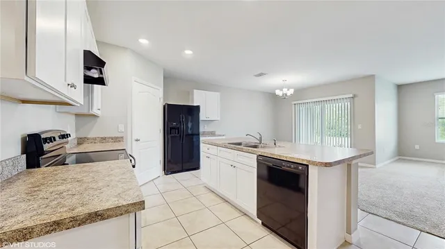 a kitchen with granite countertop a sink stove and refrigerator