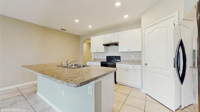 a kitchen that has a sink a stove and a refrigerator