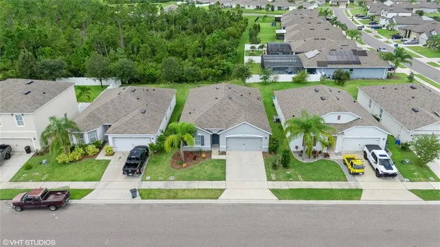an aerial view of multiple houses with a yard