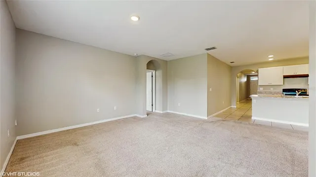 a view of empty room with kitchen