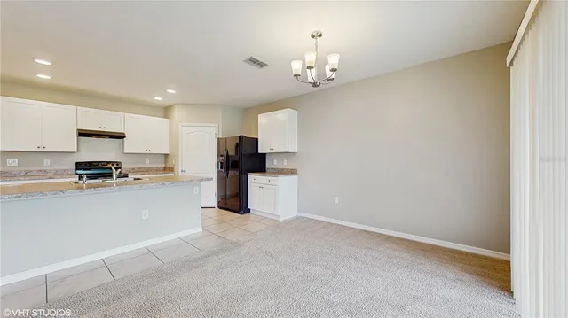 a kitchen with refrigerator and cabinets