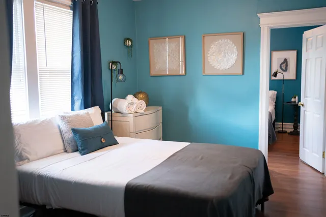 a bedroom with a bed and painting on the wall