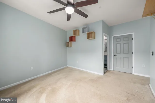 en empty room with ceiling fan and window