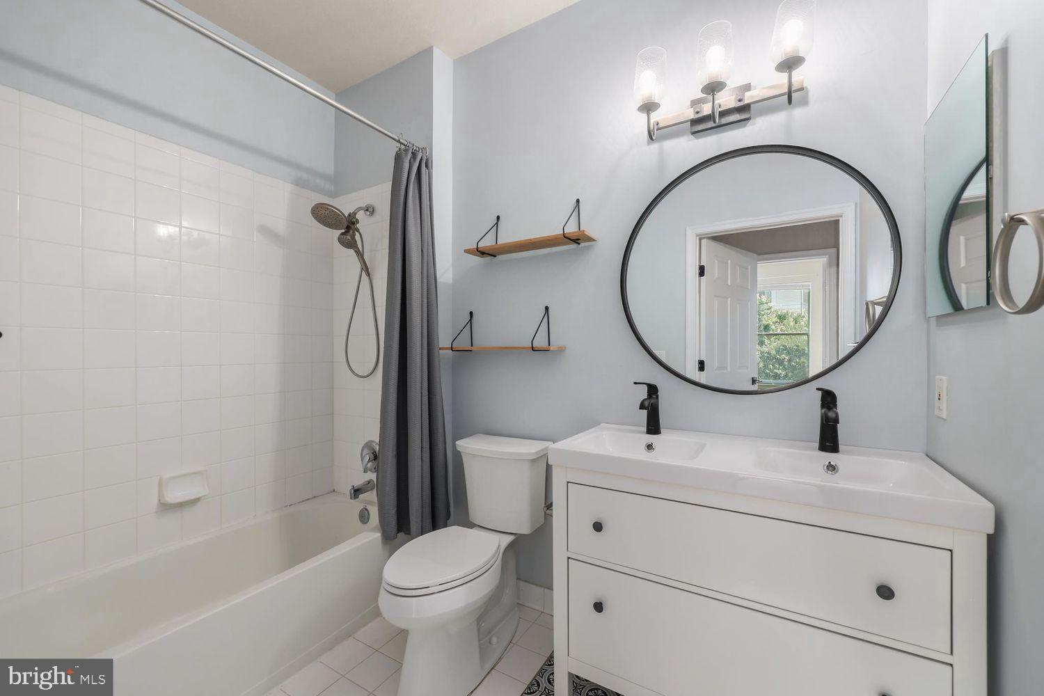 9480 Virginia Center Boulevard, Unit 329 Vienna, VA 22181 - Photo 18 of 30 a bathroom with a sink a toilet and a mirror