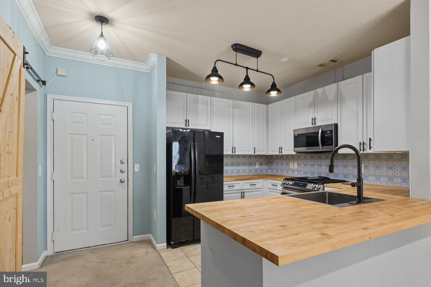 9480 Virginia Center Boulevard, Unit 329 Vienna, VA 22181 - Photo 2 of 30 a kitchen with stainless steel appliances granite countertop a refrigerator a stove a sink a microwave and wooden cabinets