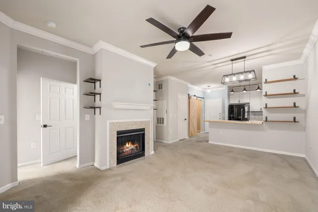 a view of a livingroom with a fireplace a ceiling fan and windows