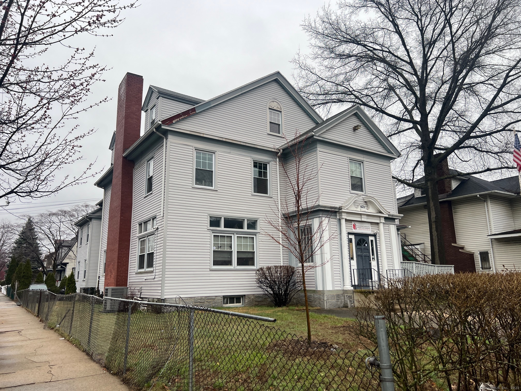 670 Clinton Avenue Bridgeport, CT 06605 - Photo 2 of 6 a white house that has a tree in front of it