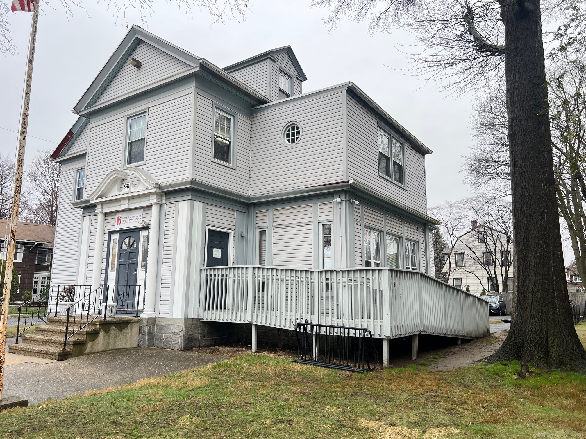 670 Clinton Avenue Bridgeport, CT 06605 - Photo 3 of 6 a view of a house with a wooden deck and a yard