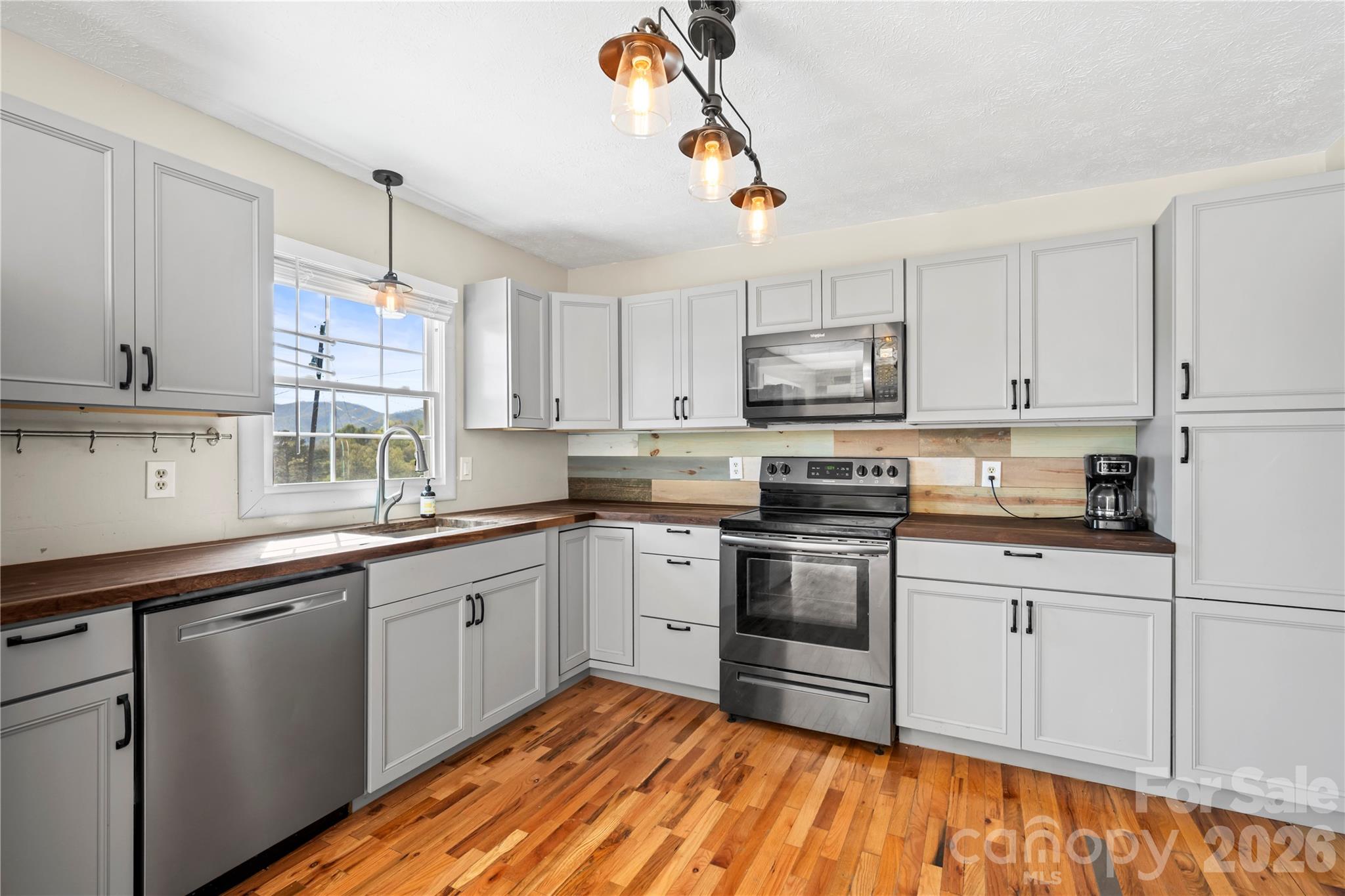 882 Queentown Road Canton, NC 28716 - Photo 14 of 33 a kitchen with stainless steel appliances granite countertop a sink cabinets and wooden floor