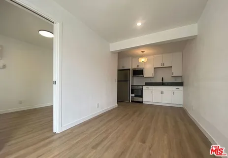 a view of a kitchen with a sink and dishwasher with wooden floor