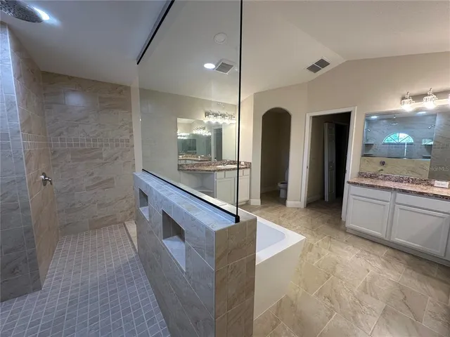 en empty room with windows and a ceiling fan