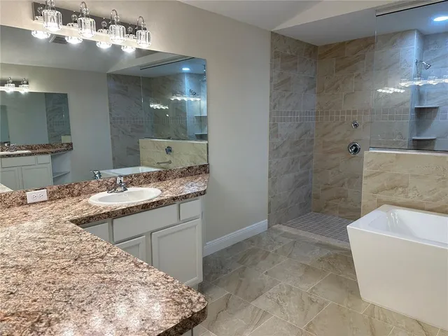 an empty room with ceiling fan and windows